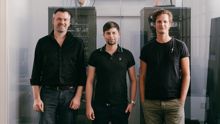 Administrations-Team vor einem Serverraum.