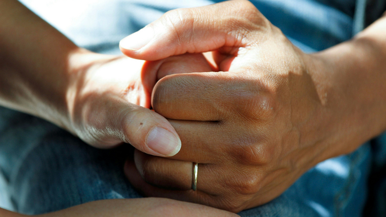 Zwei Hände halten einander. © National Cancer Institute - Unsplash
