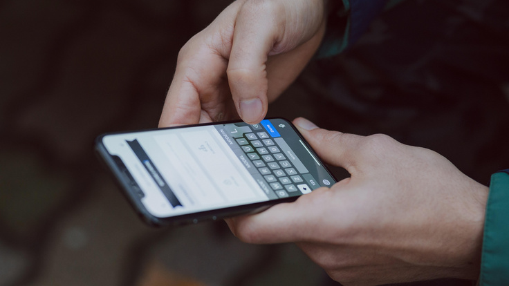 Symbolbild leichte Sprache. Zwei Hände halten ein Smartphone. es wird getippt.