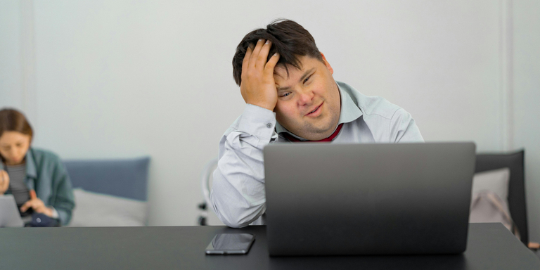 Ein Mann sitzt grübelnd vor einem Laptop